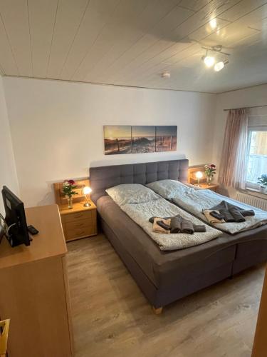 a bedroom with a bed with two shoes on it at Ferienhaus am Rathaus in Dornum