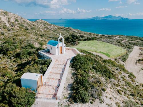 an aerial view of a chapel on a hill with the ocean at The Three Graces in Antimácheia