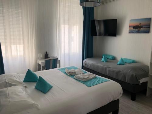 Habitación de hotel con 2 camas y TV de pantalla plana. en Le Crist'Al Hôtel de charme en bord de mer, en Saint-Georges-de-Didonne