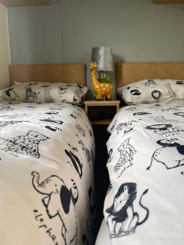 um quarto com duas camas com capas pretas e brancas em Amore Caravans em Porthcawl