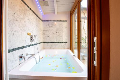 una vasca da bagno in un bagno con vasca di BolognaRoomscom - Falegnami Boutique a Bologna