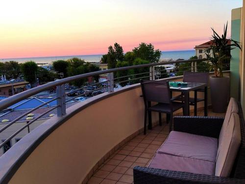 un balcone con tavolo e sedie e l'oceano di VistaMare Bluemar - The Art of the Sea - 105mq a Cattolica