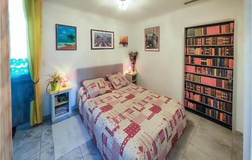 - une chambre avec un lit et une étagère avec des livres dans l'établissement 1 Bedroom Gorgeous Home In Capestang, à Capestang