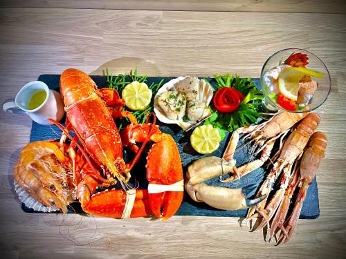 a tray of seafood and vegetables on a wooden table at 3 Sinclair Bay Lodges in Keiss