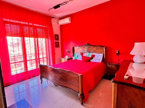 1 dormitorio con paredes rojas y 1 cama con sábanas rojas en Claudia House en Crotone