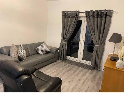 a living room with a couch and a window at Hyfrydol Bach in Maesteg