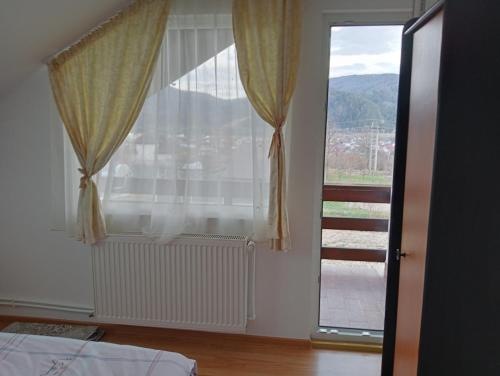 a bedroom with a large window with a view at Casa Popa in Gura Humorului