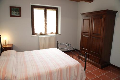 1 dormitorio con 1 cama, vestidor y ventana en Agriturismo Sant'Antonio, en Montegridolfo