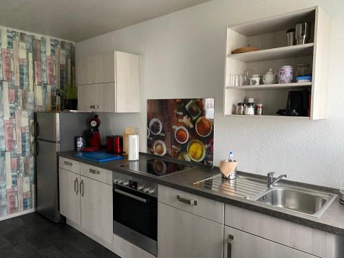 a kitchen with a sink and a refrigerator at Ferienwohnung Santino in Goslar