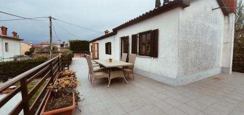 a patio with a table and chairs next to a building at Apartmaji Pajer in Koper