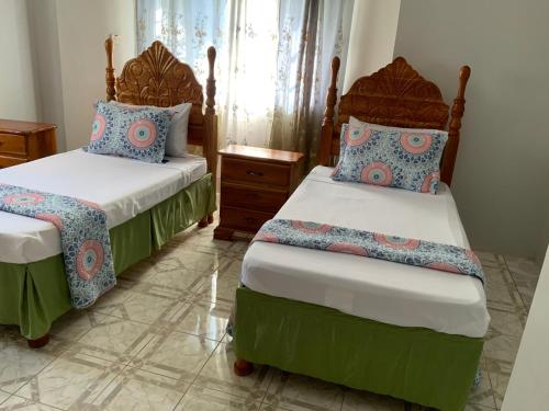 two beds in a room with two bedsitures at Poinciana House in Montego Bay