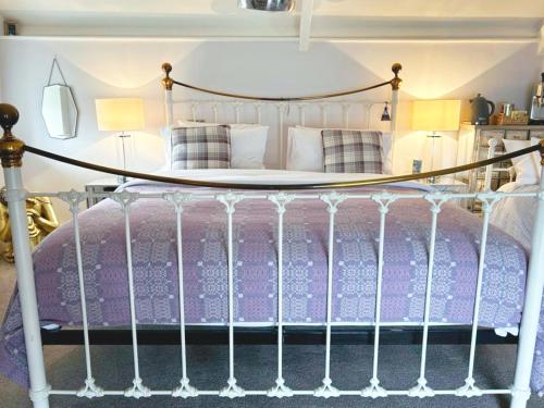 a bedroom with a bed with a wrought iron bed frame at Dylan Thomas Sea View in Laugharne