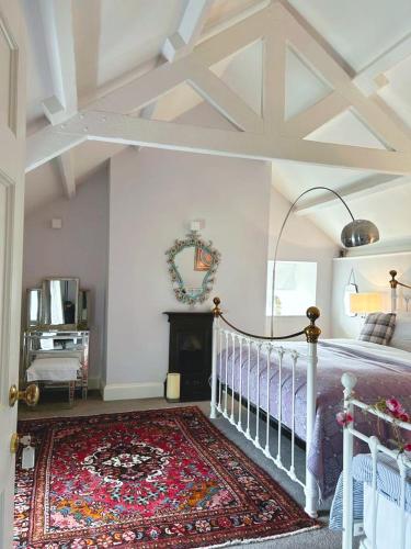 a bedroom with a bed and a fireplace and a rug at Dylan Thomas Sea View in Laugharne