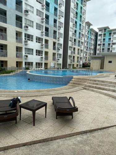 ダバオシティにある2 BR Unit In Seawind Condo [New&FullyFurnished]のベンチ2台付きの建物内のスイミングプール