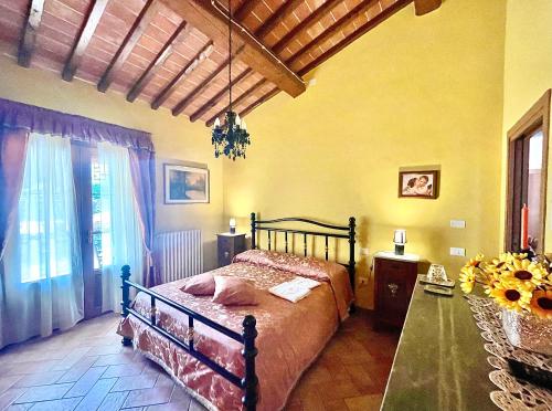 Un dormitorio con una cama y una mesa. en Agriturismo Rosa dei Venti, en Pomarance