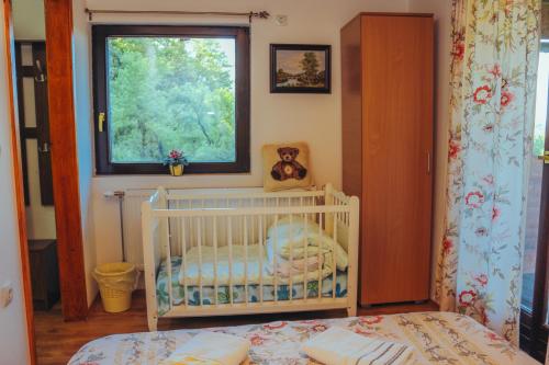 a baby crib in a room with a window at Etno domaćinstvo Milenković in Despotovac