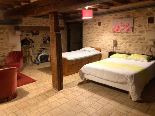 1 dormitorio con 2 camas en una habitación con paredes de piedra en chambre privée en Lombron