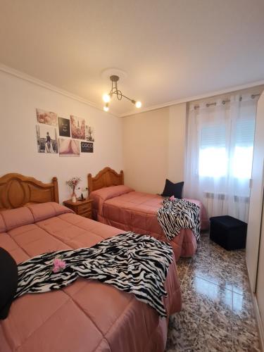 a bedroom with two beds with zebra sheets at Valle Paraiso in Cepeda