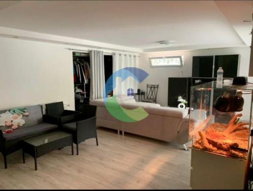a living room with a couch and a fish tank at appartement au rez de jardin in Morangis