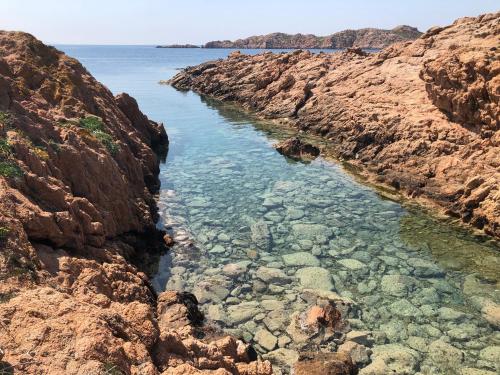 a body of water between some rocks at Miramare Isola Rossa in Isola Rossa