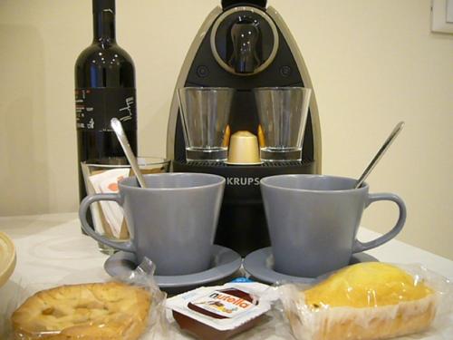 einen Tisch mit zwei Kaffeetassen und einer Flasche Wein in der Unterkunft Grignetti Bed in Triest