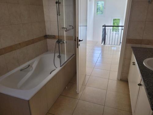 a bathroom with a bath tub and a sink at ELeAN VILLA in Paphos City