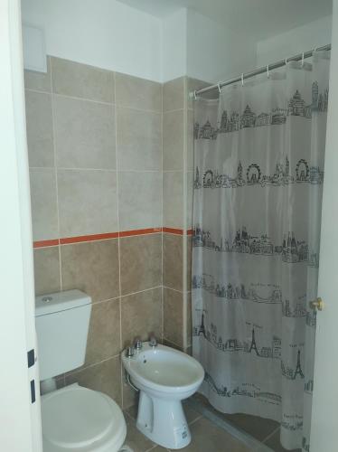 a bathroom with a toilet sink and a shower curtain at Departamento Mexico in Cedro