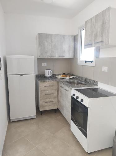 a kitchen with a white stove and a refrigerator at Departamento Mexico in Cedro