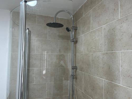 a shower with a shower head in a bathroom at Affordable Long Stay Private Rooms A Few Minutes From The City - Wolverhampton in Wolverhampton