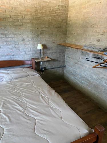 a large bed in a room with a lamp and shelves at La Luisa in Termas del Daymán