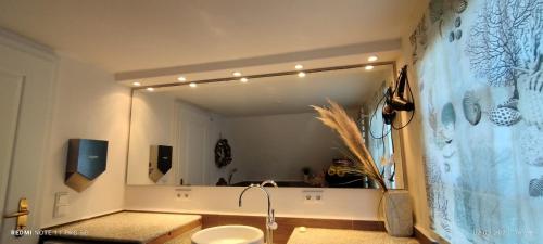 a bathroom with a sink and a large mirror at Privates Domizil auf Sylt in Strandnähe in Westerland