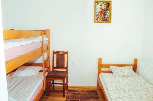 a bedroom with two bunk beds and a chair at Etno domaćinstvo Milenković in Despotovac