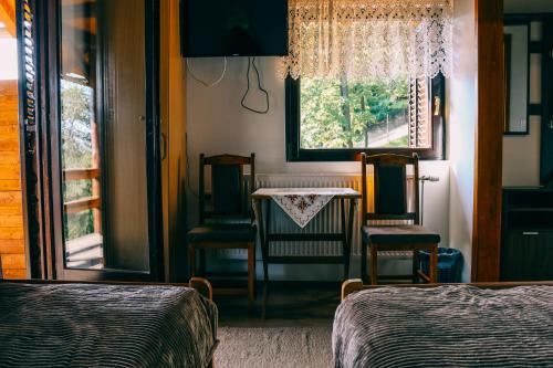 a bedroom with two beds and a table and chairs at Etno domaćinstvo Milenković in Despotovac
