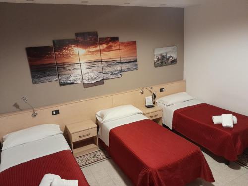 a room with two beds with red sheets at Nautilus Hotel in La Spezia