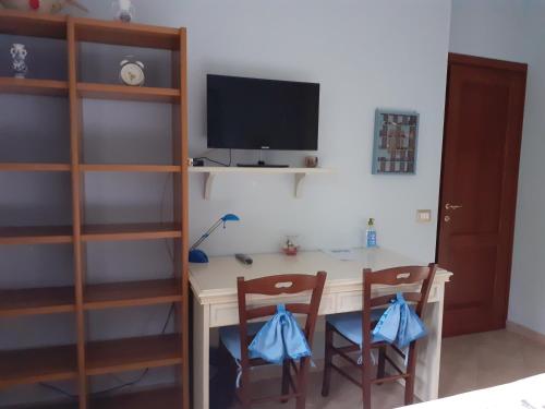 una camera con scrivania, 2 sedie e TV di La Casa Più Sù a Manziana
