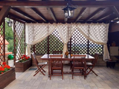 un gazebo con tavolo e sedie su un patio di La Casa Più Sù a Manziana