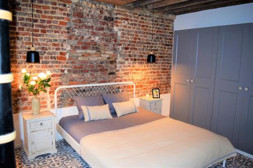 um quarto com uma cama com uma parede de tijolos em Home Sweet Home Brussels center em Bruxelas