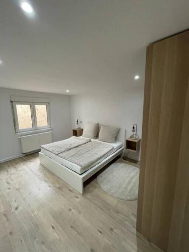 a white bedroom with a bed and a window at Casa Bergstraße 2 in Bensheim