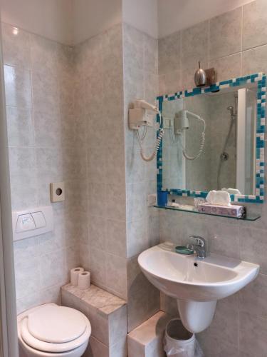 a bathroom with a sink and a toilet and a mirror at Nautilus Hotel in La Spezia