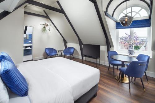 - une chambre avec un lit, une table et des chaises dans l'établissement Boutique Hotel Brasa Beemster, à Middenbeemster