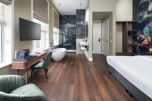 a large bathroom with a large bed and a tub at Boutique Hotel Brasa Beemster in Middenbeemster