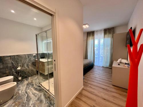 a bathroom with a glass shower and a bedroom at verona rooms 109 in Verona