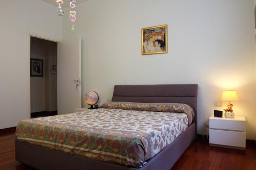 um quarto com uma cama e um candeeiro sobre uma mesa em Casa Di Ariel em La Spezia