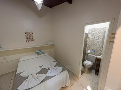 a small bedroom with a bed and a toilet at Mambuca Village in Ubatuba