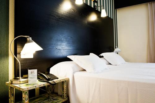 Un pat sau paturi într-o cameră la HRC Hotel
