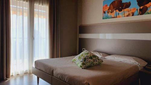 a bed with a pillow on it in a bedroom at Stampa 1968 Hotel e Ristorante in Lavena Ponte Tresa