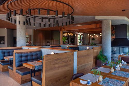 um restaurante com mesas e cadeiras e um lustre em Mirante da Colyna Hotel & SPA em Monte Verde