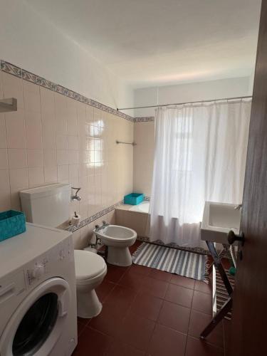 a bathroom with a toilet sink and a washing machine at Olhos do mar 209 grande terraço vista mar in Olhos de Água