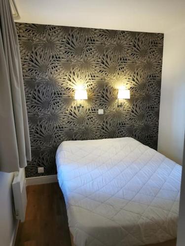 - une chambre avec un lit et deux lumières sur le mur dans l'établissement Appartement rénové, piscine à débordement, vue mer, à Cannes