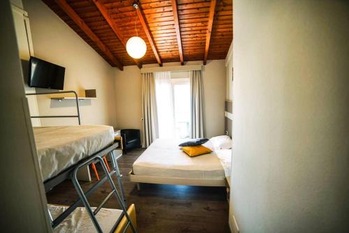 a small room with two beds and a window at Stampa 1968 Hotel e Ristorante in Lavena Ponte Tresa